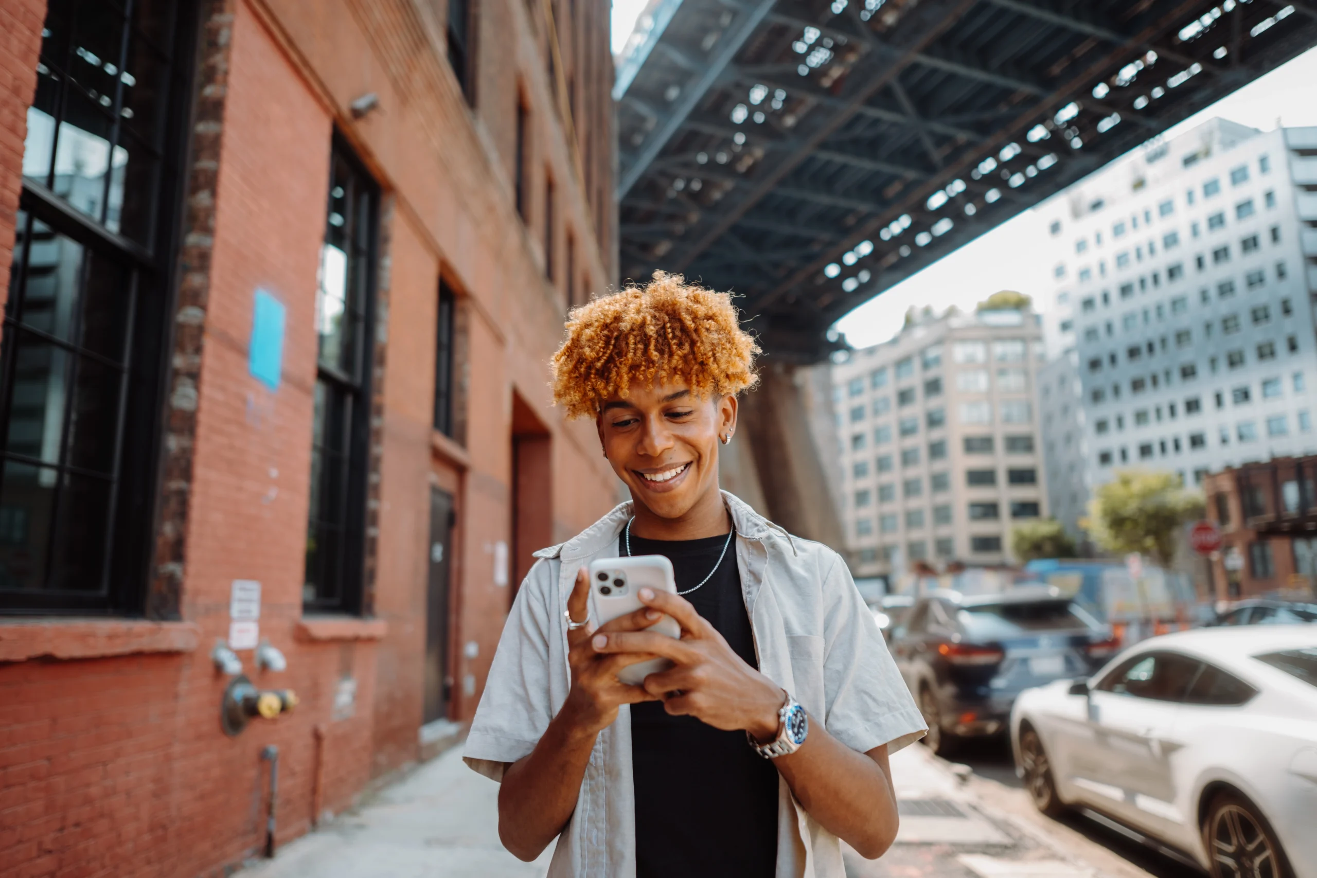 Young man smiling while using AI-assisted shopping tools on his phone